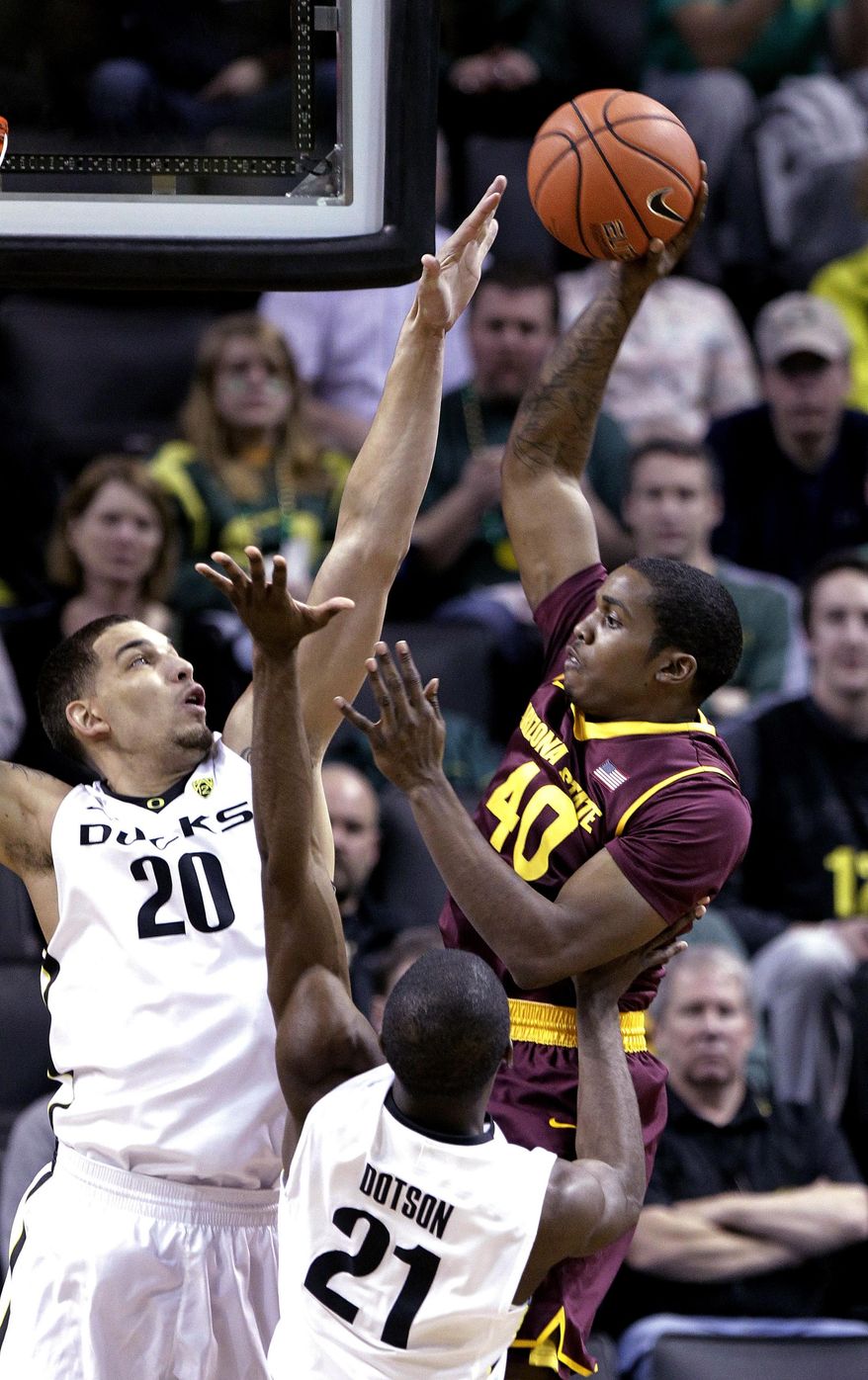 Arizona State forward Shaquielle McKissic, right, shoots against Oregon's Waverly Austin, left, and Damyean Dotson during the first half of an NCAA college basketball game in Eugene, Ore., Tuesday, March 4, 2014. (AP Photo/Don Ryan)