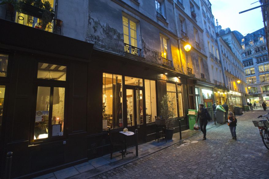 Pedestrians walk past Chef Greg Marchand's restaurant Frenchie in Paris on Thursday, Feb. 13, 2014. Center of haute cuisine, Paris has been a relative latecomer to the idea of fresh food with local ingredients at prices more for the masses. Marchand, who had by then spent his professional life abroad, was unwittingly ready. (AP Photo/Michel Euler)