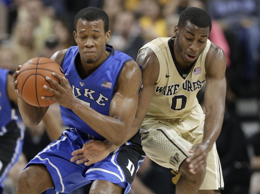 Duke's Rodney Hood, left, grabs the ball as Wake Forest's Codi Miller-McIntyre, right, defends during the first half of an NCAA college basketball game in Winston-Salem, N.C., Wednesday, March 5, 2014. (AP Photo/Chuck Burton)