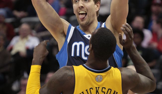 Dallas Mavericks forward Dirk Nowitzki (41) holds the ball away from Denver Nuggets center J.J. Hickson (7) in the second quarter of an NBA game in Denver on Wednesday, March 5, 2014.(AP Photo/Joe Mahoney)
