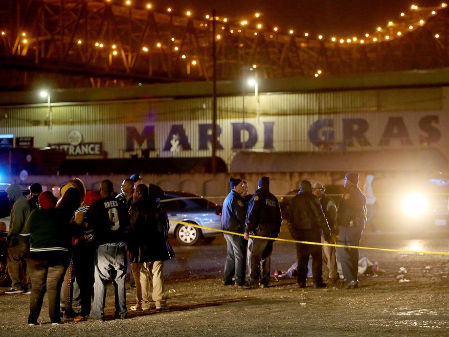 New Orleans Police investigate a double homicide in the parking lot in front of Mardi Gras World in New Orleans on Tuesday, March 4, 2014. (AP Photo/The Times-Picayune, Michael DeMocker)