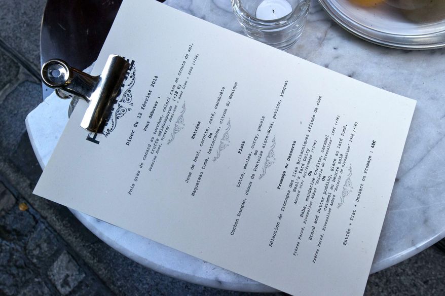 A menu is posted on a table outside chef Greg Marchand's restaurant Frenchie in Paris on Thursday, Feb. 13, 2014. Marchand’s meandering path - hotel restaurants in London and Hong Kong, a beachside bar in Spain, Jamie Oliver’s kitchen, New York’s Gramercy Tavern - put him at the crest of bistronomie, the French movement combining highbrow gastronomy and the lowly corner bistro. He returned to France in 2009, just coming into his 30s and into his own as a chef. (AP Photo/Michel Euler)