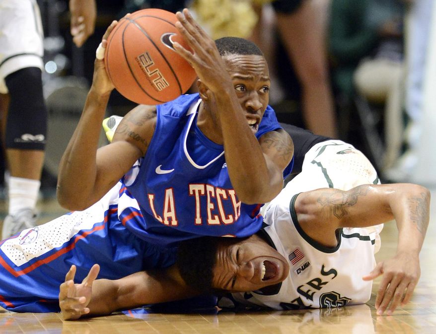 10ThingstoSeeSports - Louisiana Tech's Jaron Johnson passes the ball after colliding with UAB's Chad Frazier, bottom, during the first half of an NCAA college basketball game in Birmingham, Ala., Sunday, March 2, 2014. (AP Photo/AL.com, Mark Almond, File)