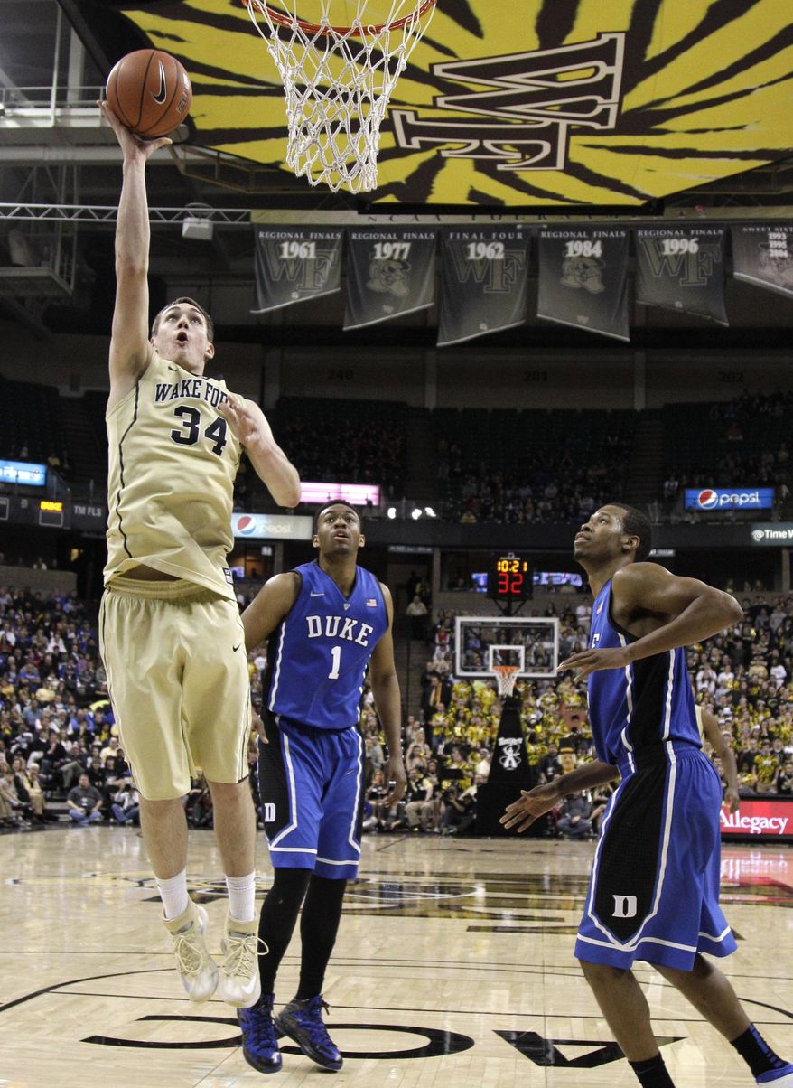 Wake Forest's Tyler Cavanaugh (34) drives to the basket past Duke's Jabari Parker (1) and Rodney Hood (5) during the second half of an NCAA college basketball game in Winston-Salem, N.C., Wednesday, March 5, 2014. Wake Forest won 82-72. (AP Photo/Chuck Burton)
