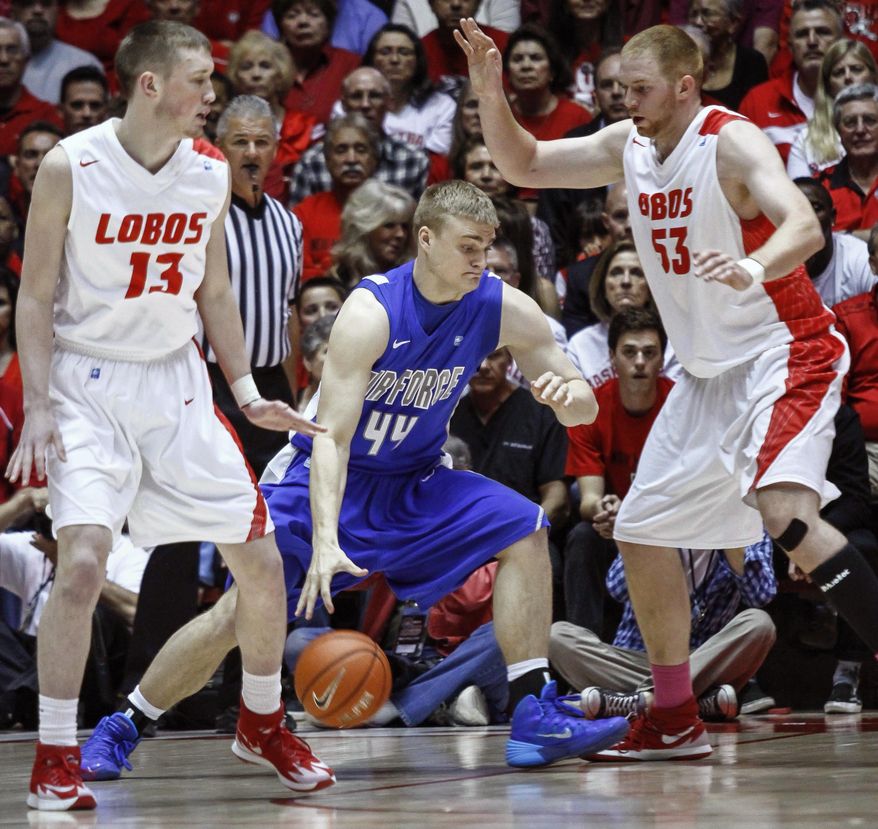 Air Force&#39;s Chase Kammerer (44) drives to the hoop guarded by New Mexico&#39;s Alex Kirk (53) and Cullen Neal (13) during the first half of an NCAA college basketball game at The Pit in Albuquerque, N.M., Wednesday, March 5, 2014. (AP Photo/Juan Antonio Labreche)