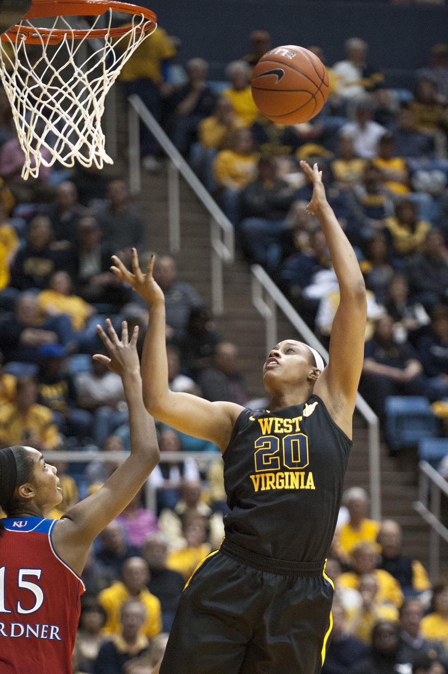 West Virginia's Asya Bussie (20) drives to the basket over Kansas' Chelsea Gardner during the second half of an NCAA college basketball game against Kansas, Tuesday, March 4, 2014, in Morgantown, W.Va. West Virginia won 67-60. (AP Photo/Andrew Ferguson)
