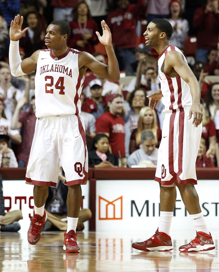 Oklahoma's Buddy Hield (24) and Cameron Clark react during an NCAA college basketball game against West Virginia in Norman, Okla., Wednesday, March 5, 2014. (AP Photo/Garett Fisbeck)