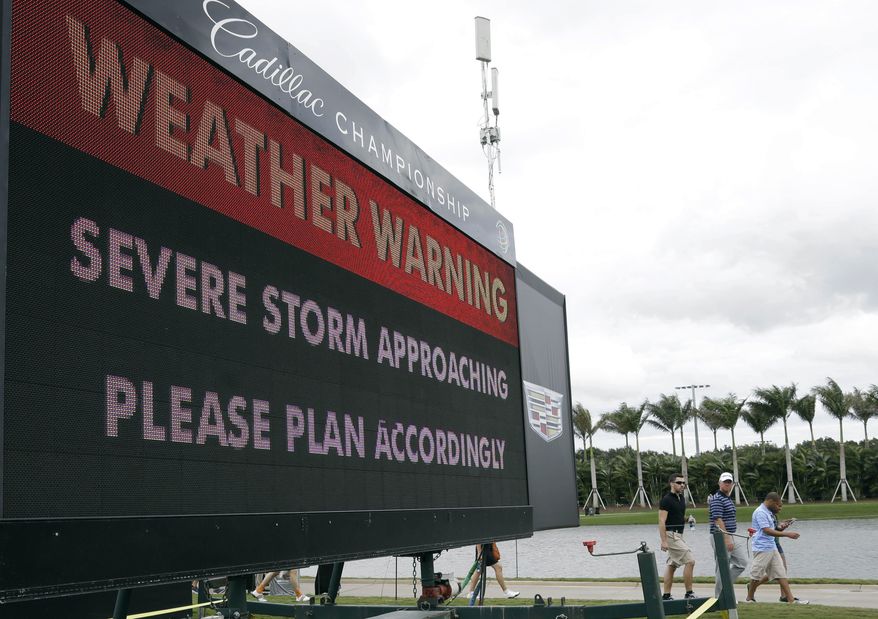 Spectators leave the golf course after play was suspended due to approaching inclement weather during the first round of the Cadillac Championship golf tournament, Thursday, March 6, 2014, in Doral, Fla. (AP Photo/Lynne Sladky)
