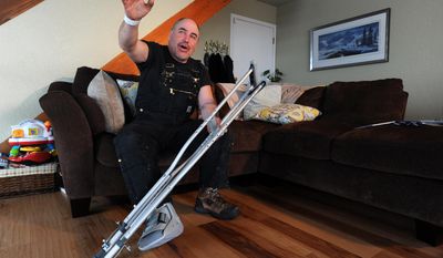 Iditarod musher Scott Janssen describes his overnight ordeal while wearing a boot for his broken foot on Wednesday afternoon, March 5, 2014, at his south Anchorage, Alaska, home. Janssen, an Anchorage undertaker known as the Mushing Mortician, was airlifted off the trail to an Anchorage hospital for treatment for a concussion along with a broken bone. (AP Photo/Anchorage Daily News, Erik Hill)