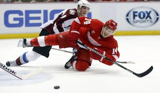 Detroit Red Wings&#39; Gustav Nyquist (14), of Sweden, is knocked off his feet by Colorado Avalanche&#39;s Matt Duchene while trying to take a shot during the second period of an NHL hockey game Thursday, March 6, 2014, in Detroit. (AP Photo/Duane Burleson)