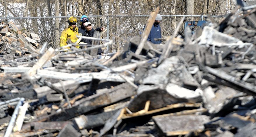 Officials from the ATF and Detroit Fire Department survey the debris from a 4-alarm fire at the Jason Manor Apartments on Jason at Schoolcraft on the Northside of Detroit, Thursday, March 6, 2014. Firefighters battled the blaze early Wednesday morning and now officials have confirmed, the fire that left dozens of residents homeless, was caused by arson. (AP Photo/ The Detroit News, Todd McInturf)