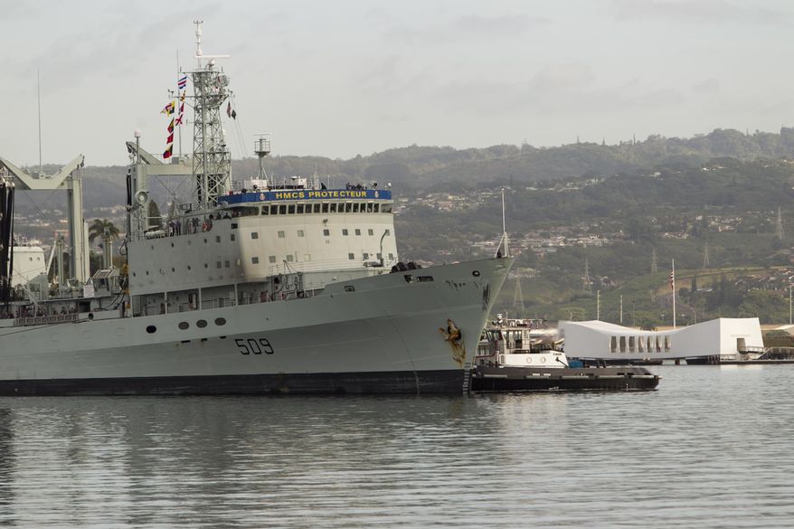 With the USS Arizona Memorial in the background, the Royal Canadian ship HMCS Protecteur is towed into Joint Base Pearl Harbor-Hickam after suffering an engine fire aboard the ship while at sea, Thursday, March 6, 2014, in Honolulu. The ship got help from the U.S. Navy after the fire broke out last week, leaving 20 sailors with minor injuries, the Royal Canadian Navy said. (AP Photo/Marco Garcia)