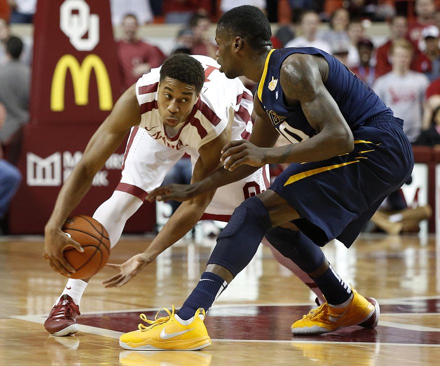 Oklahoma's Isaiah Cousins , left, fakes out West Virginia's Eron Harris (10) during an NCAA game between Oklahoma and West Virginia at the Lloyd Noble Center in Norman, Okla., Wednesday, March 5, 2014. (AP Photo/Garett Fisbeck)