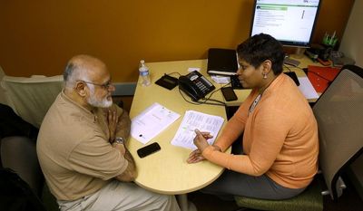 FILE - In this Jan. 9, 2013 file photo, H&amp;R Block Tax preparer Tracey Wales, right, working with customer Muneer Sheikh, on preparing his taxes, at an H&amp;R Block office downtown in Washington. H &amp; R Block reports quarterly earnings on Thursday, March 6, 2014. (AP Photo/Pablo Martinez Monsivais, File)