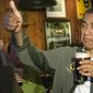 President Obama gives the thumbs up while holding a beer.
