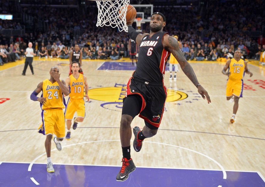 FILE - In this Jan. 17, 2013, file photo, Miami Heat forward LeBron James, second from right, goes up for a dunk as Los Angeles Lakers guard Kobe Bryant, left, guard Steve Nash, second from left, and forward Metta World Peace look on during the first half of their NBA basketball game in Los Angeles. The photo was part of a series of images by photographer Mark J. Terrill which won the Thomas V. diLustro best portfolio award for 2013 given out by the Associated Press Sports Editors during their annual winter meeting in Indianapolis. (AP Photo/Mark J. Terrill, File)