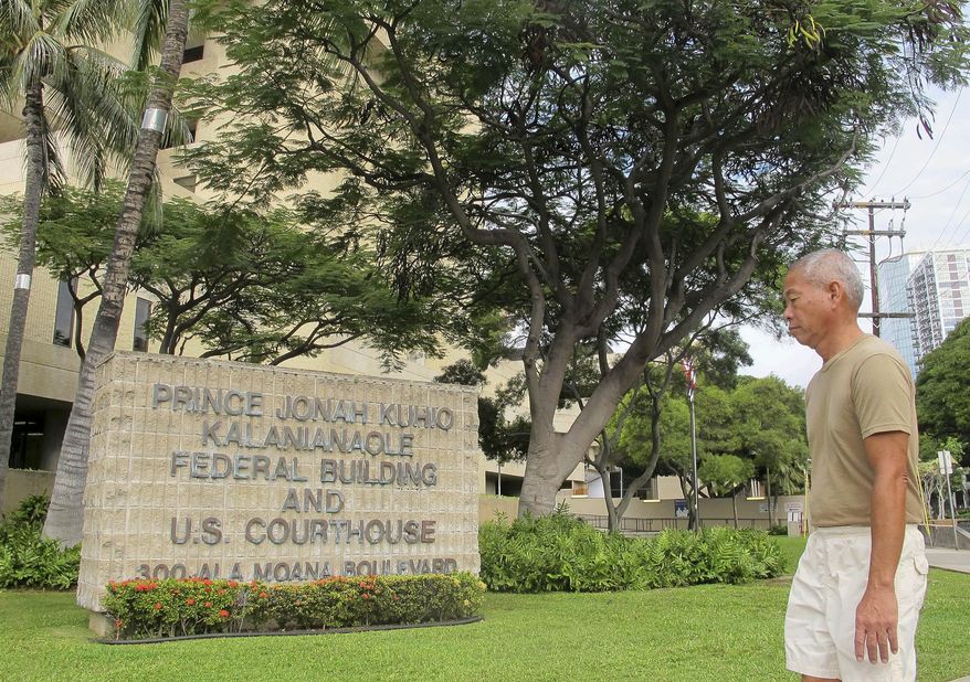 A pedestrian walks in front of the federal building housing U.S. District Court in Honolulu on Friday, March 7, 2014. A courtroom in this building s set to become the scene of a death penalty trial even though Hawaii abolished capital punishment in 1957. (AP Photo/Audrey McAvoy)