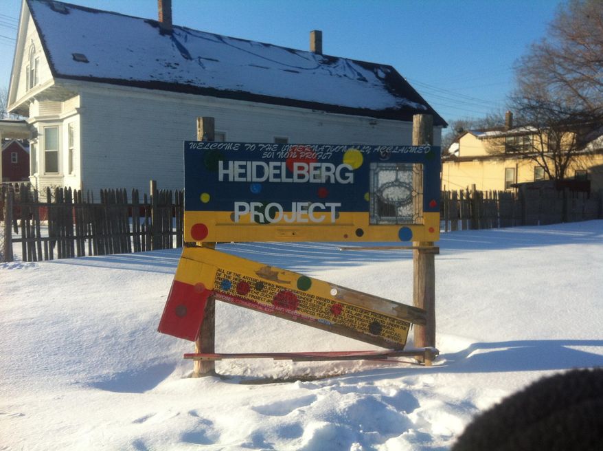In this Friday, March 7, 2014 photo, a sign welcoming visitors to the Heidelberg Project outdoor art installation is shown in Detroit. The sign sits not far from the site of a house that was destroyed by fire earlier in the day. The home, known as the "Party Animal" house or "Doll House," was part of the Heidelberg Project, which has been the target of at least eight suspicious fires since May. (AP Photo, Mike Householder)