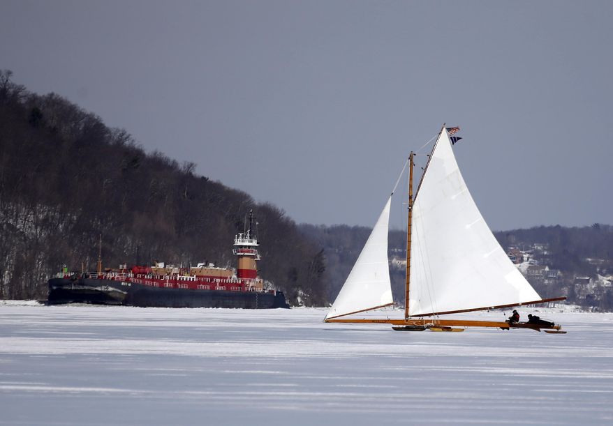 The ice boat Jack Frost sails along on the Hudson River as a commercial ship heads south on Saturday, March 1, 2014, in Barrytown, N.Y. (AP Photo/Mike Groll)