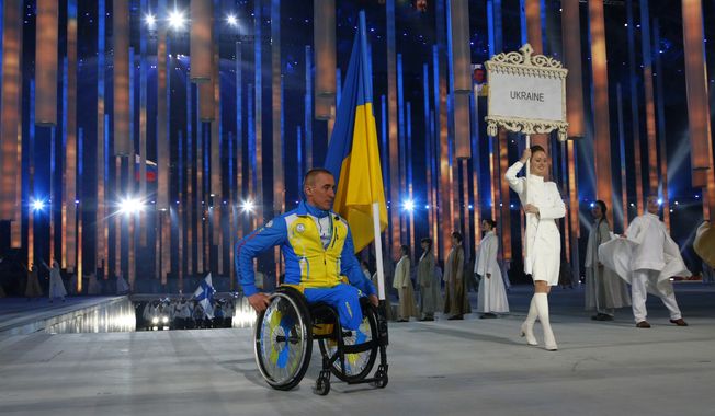 Biathlete Mykhaylo Tkachenko, representing Ukraine, enters the arena during the opening ceremony of the 2014 Winter Paralympics at the Fisht Olympic stadium  in Sochi, Russia, Friday, March 7, 2014.  (AP Photo/Dmitry Lovetsky)
