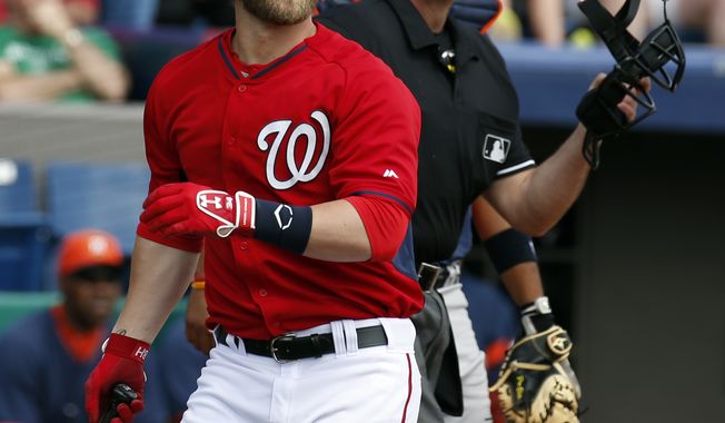 Washington Nationals&#x27; Bryce Harper, left, watches his two-run homer with home plate umpire Paul Nauert in the first inning of a spring exhibition baseball game against the Houston Astros, Friday, March 7, 2014, in Viera, Fla. (AP Photo/Alex Brandon)