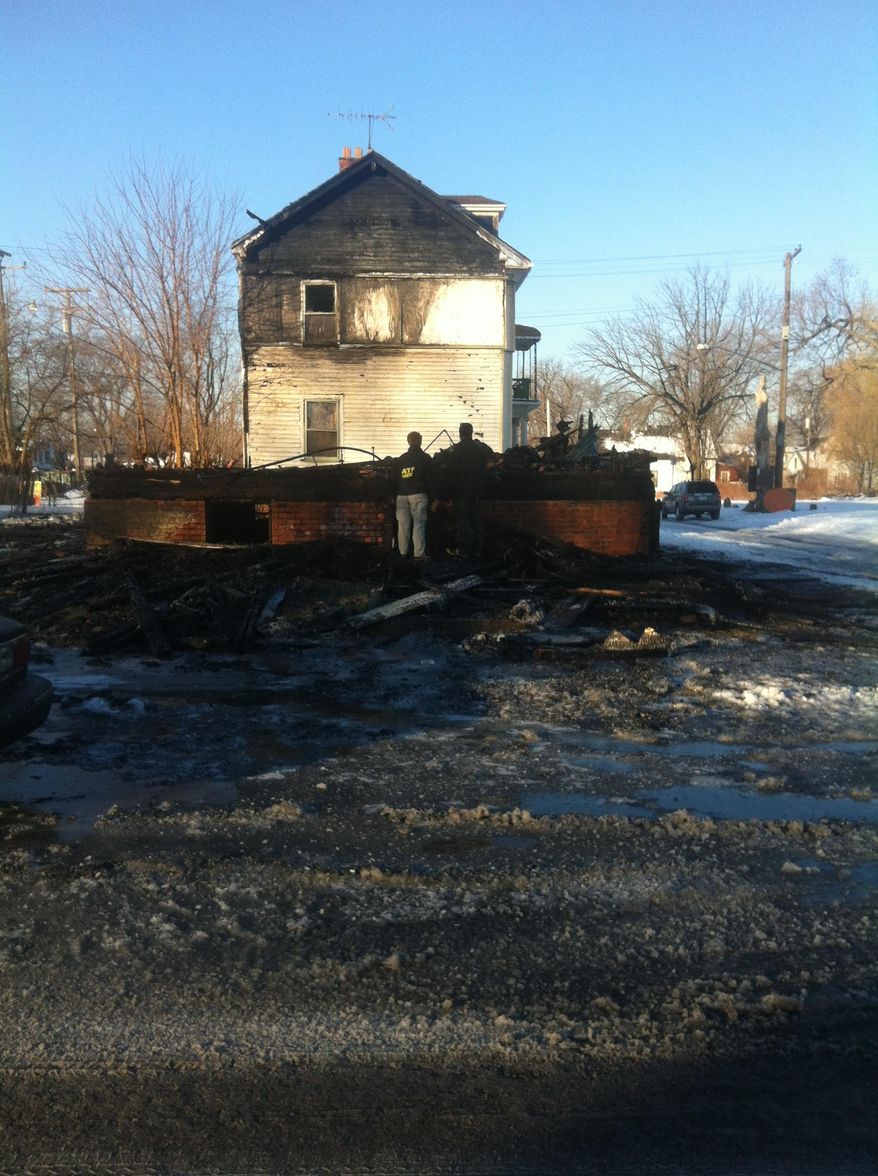 Two investigators with the U.S. Bureau of Alcohol, Tobacco, Firearms and Explosives look over the remnants of a house destroyed by fire in Detroit on Friday, March 7, 2014. The home, known as the "Party Animal" house or "Doll House," was part of the Heidelberg Project interactive outdoor art installation that has been the target of at least eight suspicious fires since May. (AP Photo, Mike Householder)
