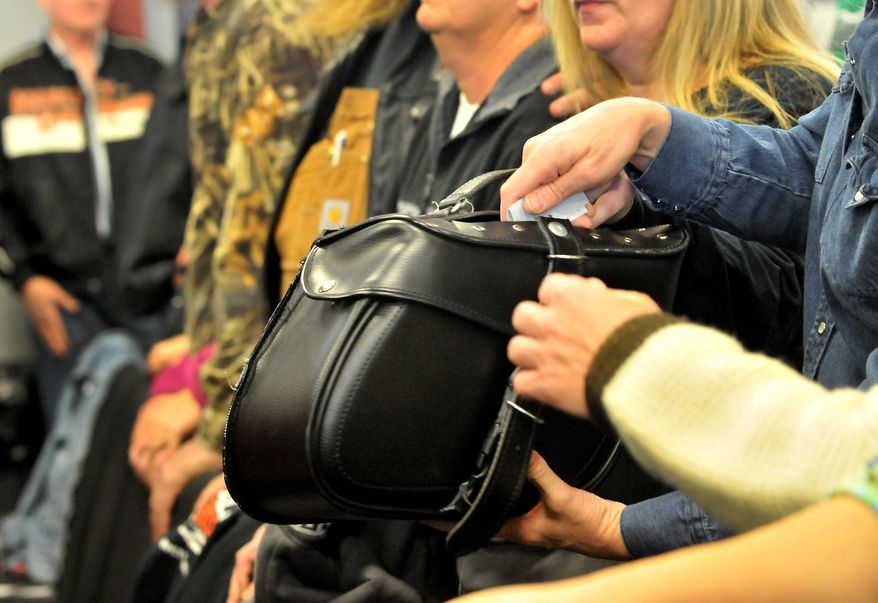 Bike saddle bags are passed around for the offering at the Freedom Biker Church Sunday, Feb. 16, 2014. (AP Photo/The Fayetteville Observer, Cindy Burnham.)