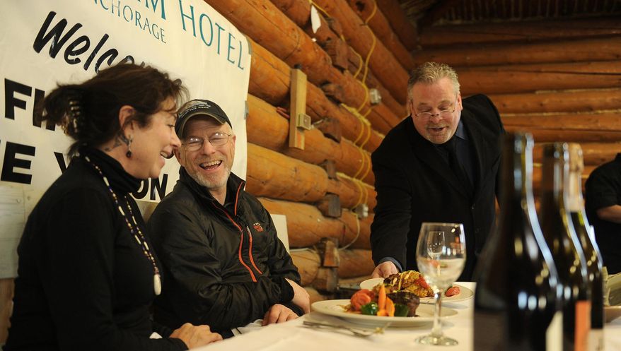 Former Iditarod executive director and former Ruby resident Raine Hall shares the five-course meal with Jeff King after he was the first musher to reach the Yukon River checkpoint of Ruby during the Iditarod Trail Sled Dog Race on Thursday, March 6, 2014. A chef from the Millennium Hotel in Anchorage prepared the meal. (AP Photo/The Anchorage Daily News, Bob Hallinen)