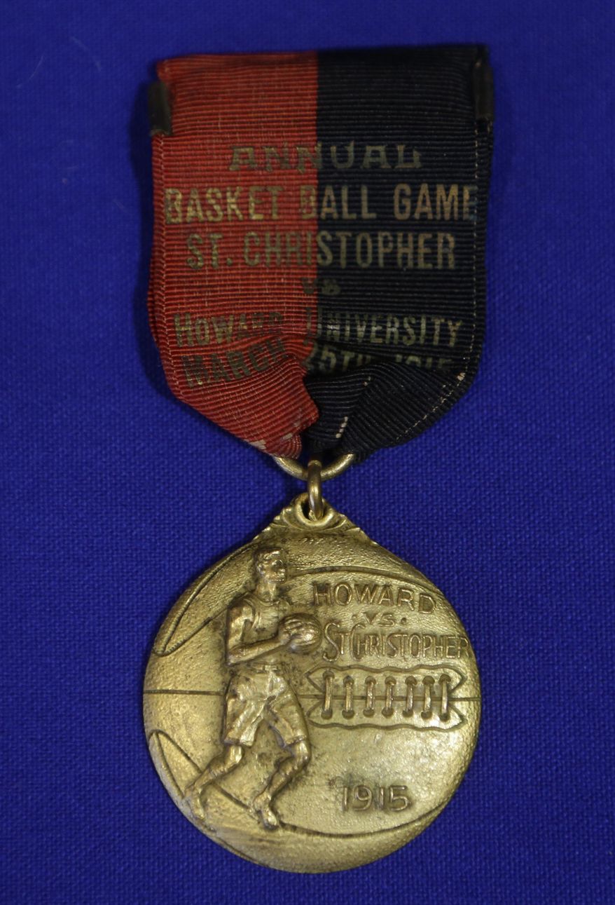 In this Feb. 19, 2014 photo, a souvenir medallion for a basketball game played between Howard University and St. Christopher is part of an exhibit entitled "The Black Fives," at the New-York Historical Society in New York. Dozens of teams flourished between 1904 and 1950 in what became known as the Black Fives Era, an often-overlooked piece of black history that is the subject of an exhibition opening at the New-York Historical Society on March 14. (AP Photo/Frank Franklin II)