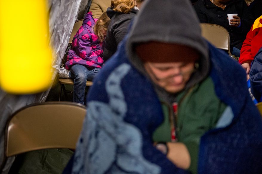 A tired Breanna Fitzgerald, 7, of Buena Vista, Va., left, waits in a warming tent with her mother in the cold pre-dawn hours to be let into the Remote Area Medical's facilities to be seen by a doctor at Southern Virginia University, Buena Vista, Va., Saturday, March 1, 2014. Remote Area Medical Volunteer Corps (RAM) is a Knoxville, Tennessee-based, non-profit, volunteer, airborne medical relief corps that provides free health care, dental care, eye care, veterinary services, and technical and educational assistance to people in remote areas of the United States, and around the world for people that need it. (Andrew Harnik/The Washington Times)