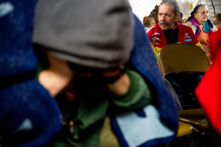 Roy Campbell of Buena Vista, Va., second from right, and Jenny Kulp, right, and others waits in a warming tent in the cold pre-dawn hours to be let into the Remote Area Medical's facilities to be seen by a doctor at Southern Virginia University, Buena Vista, Va., Saturday, March 1, 2014. Remote Area Medical Volunteer Corps (RAM) is a Knoxville, Tennessee-based, non-profit, volunteer, airborne medical relief corps that provides free health care, dental care, eye care, veterinary services, and technical and educational assistance to people in remote areas of the United States, and around the world for people that need it. (Andrew Harnik/The Washington Times)