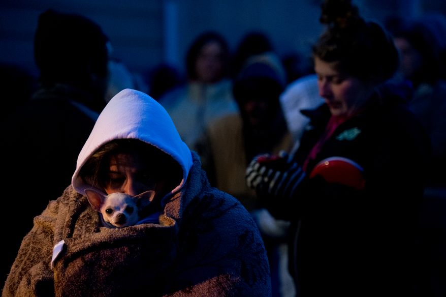 Bridget Morrill of Raphine, Va. and her dog Rox try to stay warm in the cold pre-dawn hours as she waits to be let into the Remote Area Medical's facilities to be seen by a doctor at Southern Virginia University, Buena Vista, Va., Saturday, March 1, 2014. Remote Area Medical Volunteer Corps (RAM) is a Knoxville, Tennessee-based, non-profit, volunteer, airborne medical relief corps that provides free health care, dental care, eye care, veterinary services, and technical and educational assistance to people in remote areas of the United States, and around the world for people that need it. (Andrew Harnik/The Washington Times)