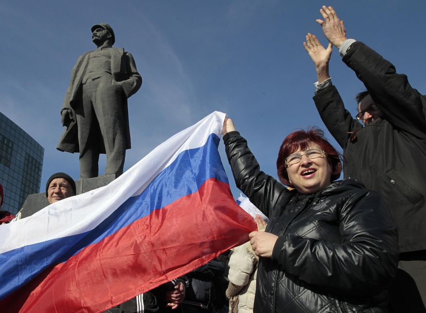 People shout slogans as they stand next to a statue of Soviet revolutionary leader Vladimir Lenin during a pro Russian rally at a central square in Donetsk, Ukraine, Saturday, March 8, 2014. Pro Russian activists continued to gather on Saturday in the eastern Ukrainian city of Donetsk, as Russia was reported to be reinforcing its military presence in Crimea. (AP Photo/Sergei Chuzavkov)