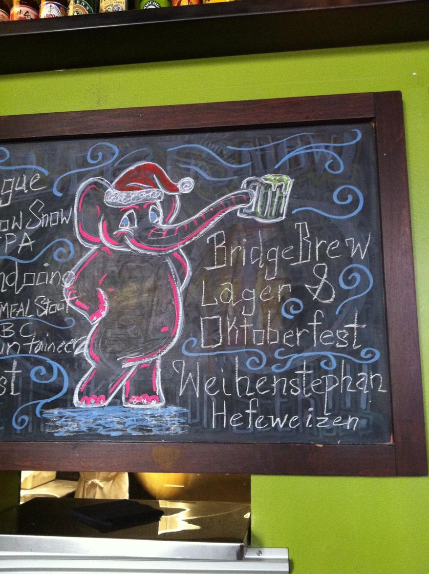 ADVANCE FOR SUNDAY MARCH 9 AND THEREAFTER This Friday Feb. 28, 2014 photo shows one of bartender Devin Fields works on the sandwich board of Pies and Pints’ in Charleston, W.Va. Fields is the go-to guy when the Capitol Street restaurant needs a fresh design for its sandwich board. He fills the chalkboard with favorite cartoon and movie characters, and also comes up with original designs for holidays or downtown events. (AP Photo/Charleston Daily Mail, Robert Wojcieszak)