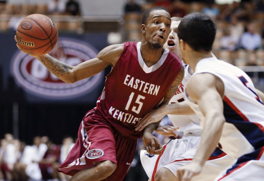 Eastern Kentucky guard Orlando Williams (15) drives against Belmont defenders Evan Bradds, center, and Caleb Chowbay (5) during the first half of an NCAA college basketball game for the championships of the Ohio Valley Conference men's tournament, Saturday, March 8, 2014, in Nashville, Tenn. (AP Photo/Mark Humphrey)