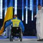 Biathlete Mykhaylo Tkachenko, representing Ukraine, enters the arena during the opening ceremony of the 2014 Winter Paralympics at the Fisht Olympic stadium in Sochi, Russia, Friday, March 7, 2014. (AP Photo/Dmitry Lovetsky)