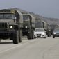 A convoy of military vehicles bearing no license plates travels on the road from Feodosia to Simferopol in the Crimea, Ukraine, Saturday, March 8, 2014. More than 60 military trucks bearing no license plate numbers was headed from the eastern city of Feodosia toward the city of Simferopol, the regional capital. (AP Photo/Darko Vojinovic)