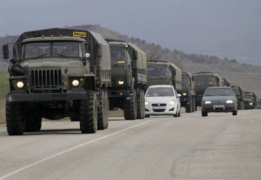 A convoy of military vehicles bearing no license plates travels on the road from Feodosia to Simferopol in the Crimea, Ukraine, Saturday, March 8, 2014. More than 60 military trucks bearing no license plate numbers was headed from the eastern city of Feodosia toward the city of Simferopol, the regional capital. (AP Photo/Darko Vojinovic)