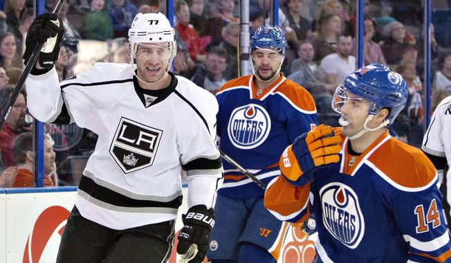 Los Angeles Kings Jeff Carter (77) celebrates a goal as Edmonton Oilers Mark Fraser (5) and Jordan Eberle (14) look on during first period NHL hockey action in Edmonton, Canada, Sunday March 9, 2014. (AP Photo/The Canadian Press, Jason Franson)