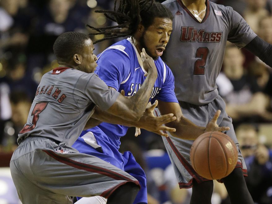 Saint Louis guard Jordair Jett, center, cannot get a handle on the ball after Massachusetts guard Chaz Williams (3) lost control during the first half of an NCAA college basketball game in Amherst, Mass., Sunday, March 9, 2014. (AP Photo/Stephan Savoia)