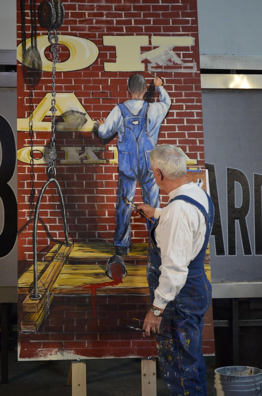 In this March 1, 2014 photo provided by the Billboard Museum Association, Inc., muralist Bob Palmer is shown at Superior Neon in Oklahoma City. Palmer was one of three artists who showcased his work at a recent workshop and demonstration to draw support for a proposed museum dedicated to billboards and vintage signs along Route 66 in Oklahoma. (AP Photo/Billboard Museum Association)