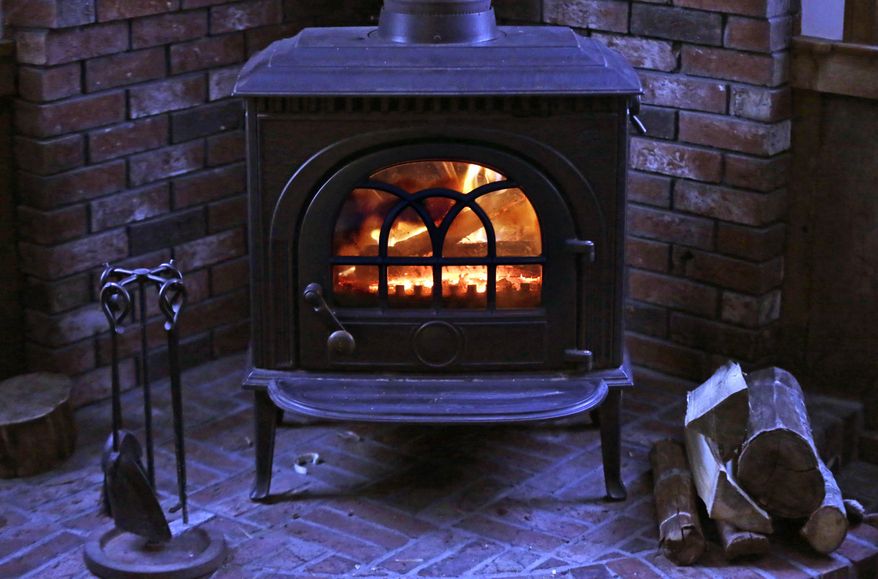 A wood stove heats a home Saturday, March 8, 2014 in Freeport, Maine. Officials in Maine worry that the U.S. Environmental Protection Agency's proposed new rules governing wood stoves will be too costly for people in the poorest state in New England. (AP Photo/Robert F. Bukaty)