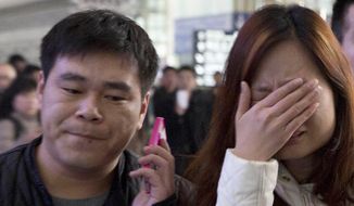 ALTERNATE CROP OF XHG102 A woman cries at the arrival hall of the International Airport in Beijing, China, Saturday, March 8, 2014. Relatives and friends were arriving at Beijing airport for news after a Malaysia Airlines Boeing 777-200 was reported missing on a flight from Kuala Lumpur to Beijing Saturday. (AP Photo/Ng Han Guan)