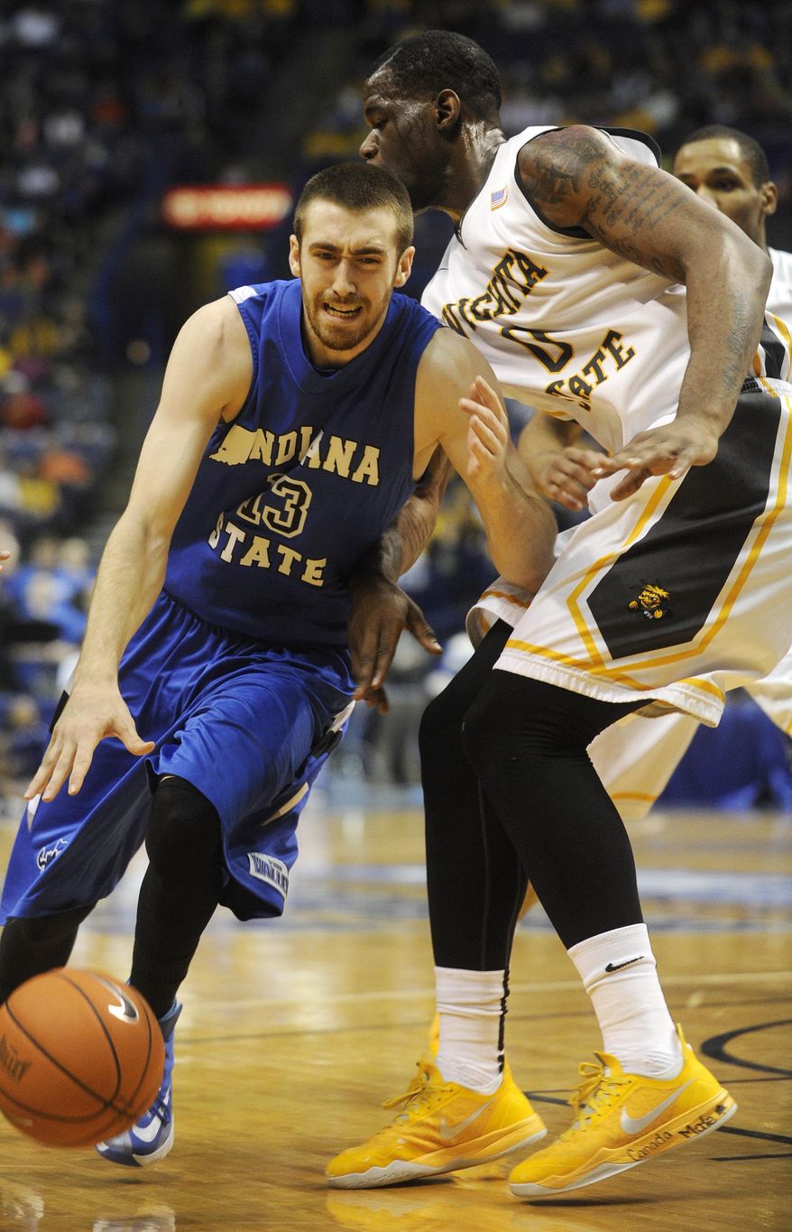 CORRECTS TO WICHITA STATE'S CHADRACK LUFILE (0) NOT CLEANTHONY EARLY (11) - Indiana State's Jake Odum (13) drives on Wichita State's Chadrack Lufile (0) in the first half of an NCAA college basketball game in the championship of the Missouri Valley Conference men's tournament on Sunday, March 9, 2014, in St. Louis. (AP Photo/Bill Boyce)