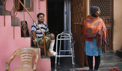 In this Feb. 20, 2014 photo, Indian man Ashok Yadav sits on a staircase outside his house, with his wife Laxmi Yadav beside him at a leper colony in New Delhi, India.  The stigma of leprosy endures in India, even though the country has made great strides against the disease, which is neither highly contagious nor fatal. Now the number of new annual cases has risen slightly after years of steady decline, and medical experts say the enormous fear surrounding leprosy is hindering efforts to finally eliminate it.(AP Photo/Manish Swarup)