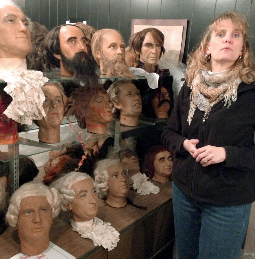 In this photo made on Thursday, March 6, 2014, Tammy Myers, who runs the American Civil War Wax Museum for FutureStake Inc., stands beside shelves of heads of characters from the museum in Gettysburg, Pa. The museum, which has occupied a prime spot near the center of the Gettysburg battlefield for over 50 years, is undergoing an extensive renovation and a new approach to history, so it is selling dozens of its historical figures, most made of vinyl, not wax, in a March 15, 2014 auction. (AP Photo/stf-Mark Scolforo)