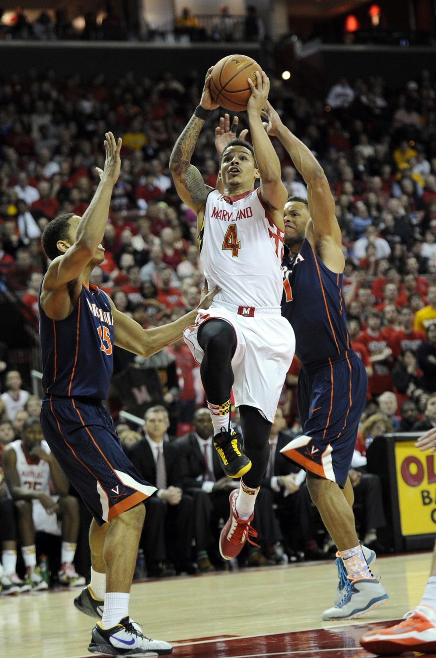 Maryland guard Seth Allen (4) goes to the basket against Virginia guard Malcolm Brogdon (15) and Justin Anderson during the second half of an NCAA college basketball game, Sunday, March 9, 2014, in College Park, Md. Maryland won 75-69 in overtime. (AP Photo/Nick Wass)