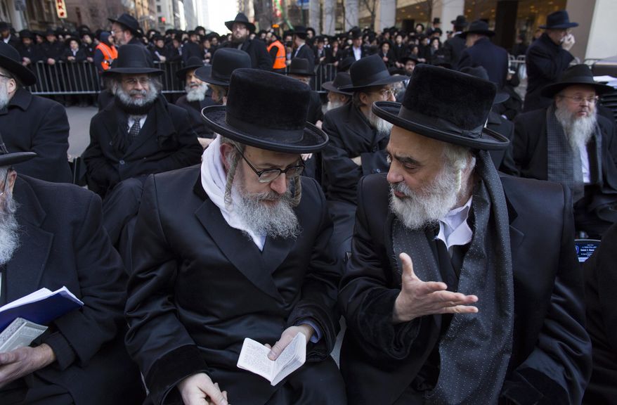 Rabbis speaks to one another as they joined other Orthodox Jews in New York, Sunday, March 9, 2014, on Water Street in lower Manhattan, to pray and protest against the Israeli government's proposal to pass a law that would draft strictly religious citizens into its army. (AP Photo/Craig Ruttle)