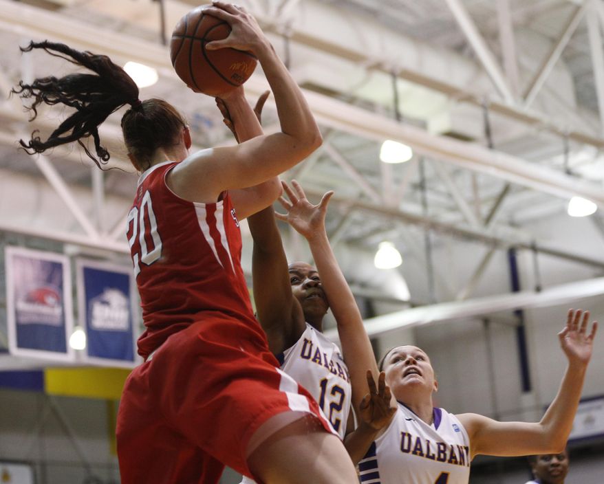 Stony Brook forward Brittany Snow (20) grabs the ball in front of Albany defenders Imani Tate (12) and Sarah Royals (4) during the first half of an NCAA America East college championship basketball game on Monday, March 10, 2014, in Albany, N.Y. (AP Photo/Mike Groll)