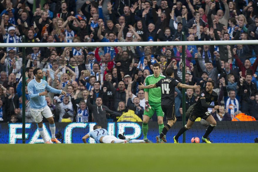 Wigan Athletic's James Perch, right, celebrates after scoring past Manchester City's goalkeeper Costel Pantilimon, center right, during their English FA Cup quarterfinal soccer match at the Etihad Stadium, Manchester, England, Sunday March 9, 2014. (AP Photo/Jon Super)
